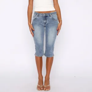 Detail view of women's stretch denim capri jeans featuring slit hem and classic wash.