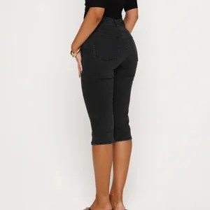 Back view detail of women's stretch denim capri jeans, highlighting high-waisted slim fit design.