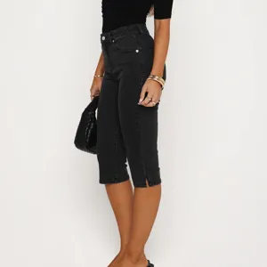 Women black stretch slit capri jeans detail view, premium denim casual pants for summer.