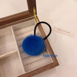 Cute fluffy pompom hair tie in vibrant Klein blue with high elasticity for women's hair.