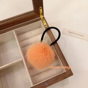 Cute fluffy pom pom hair tie detail shot, soft plush hair accessory for women styling.