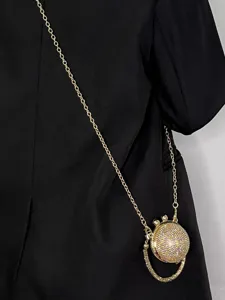Mini Strass Kristallkugel Umhaengetasche mit goldener Kette an schwarzem Outfit präsentiert