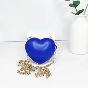 Kleine herzförmige Umhängetasche aus blauem PU-Leder mit goldener Kette im Detail.