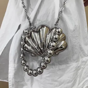 Metallische Muschel-Minischnitt-Umhängetasche mit Perlenketten-Griff für elegante Damen.