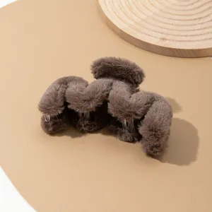 Primer plano de pinza de pelo de peluche marrón, textura suave para peinados elegantes.