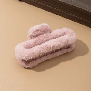 Primer plano detallado de la pinza de pelo rosa de peluche con una textura suave y dientes.