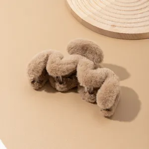 Vista detallada de la pinza de pelo de peluche marron con textura suave y agarre firme.