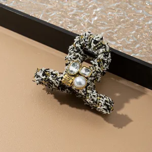 Elegante pinza de pelo de tweed para mujer, accesorio negro y dorado chic para peinados.
