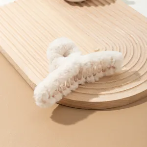 Detalle de pinza de pelo de peluche, textura de piel sintética suave, estilo de invierno.