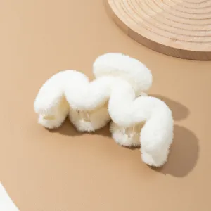 Primer plano detallado de la pinza de pelo de peluche blanco esponjoso, textura de piel sintética suave.