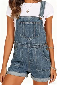 Close-up detail of blue denim overalls romper, highlighting chest pocket and metal buckles.