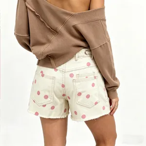 Women's polka dot denim shorts detail view showing pink dots and drawstring waist design.