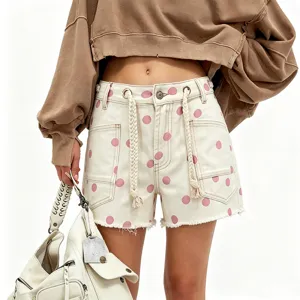 Women's chic polka dot denim shorts featuring adjustable braided drawstrings and raw hem detailing.