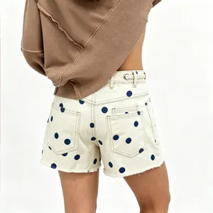 Women's polka dot denim shorts with eyelet and drawstring waist detail, casual summer style.