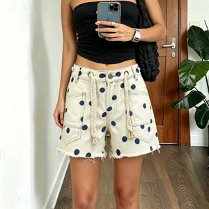 Women's chic polka dot denim shorts featuring adjustable braided drawstrings and raw hem details.