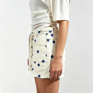 Detail view of casual polka dot denim shorts featuring a drawstring waist and eyelet accents.