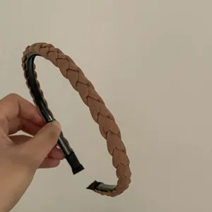 Brown braided headband detail close-up showing texture and delicate woven design accessory