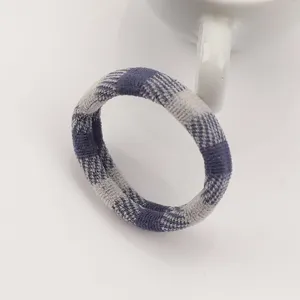 Close up detail of blue gray plaid hair tie showcasing soft and elastic textile texture.