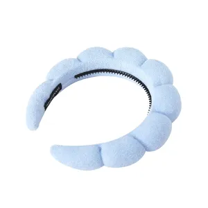 Nahaufnahme des flauschigen hellblauen Spa Stirnbands, weiche Schwamm Textur, Anti Rutsch Kamm.