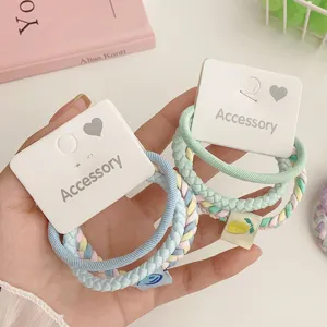 Detailed shot of cute pastel braided hair tie sets with display cards on a clean desktop.
