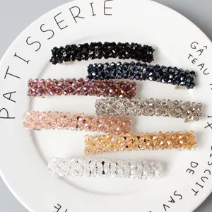 Detailed view of sparkling crystal beaded hair clips, showing fine woven spring barrette details.