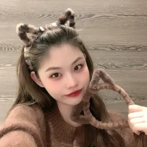 Détail de serre-tête oreilles de chat duveteux en peluche douce et ton marron chaleureux.