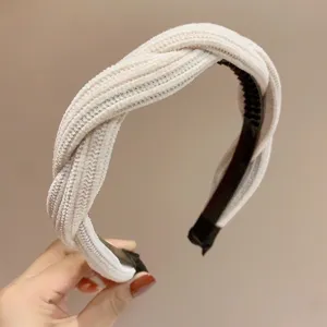 Cerchietto largo in ciniglia con denti, design intrecciato, elegante accessorio per capelli beige.
