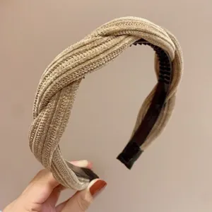 Dettaglio fascia per capelli in ciniglia intrecciata con texture e denti per uso quotidiano.