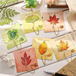 Vintage metal leaf bookmarks with delicate hollow design and hanging chains for students reading.