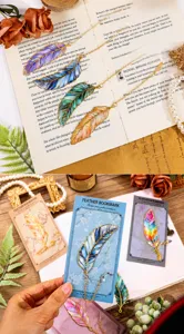 Metal feather bookmark detail shot, colorful enamel craft with delicate chain and pendant decor.