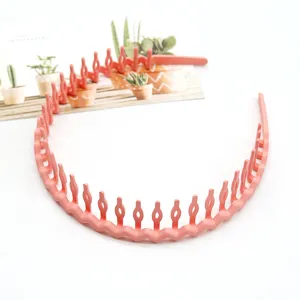 Close-up detail of coral pink plastic wavy hairband with anti-slip teeth, stylish hair accessory.