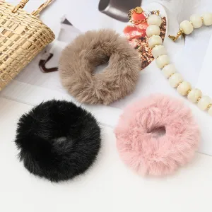 Detailed shot of soft plush fluffy hair scrunchies in multiple winter colors for cute styling.