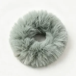 Close-up detail of fluffy faux fur hair scrunchie in soft gray, elegant winter accessory.
