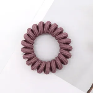 Detail shot of a braided phone wire hair tie in mauve, soft elastic hair accessory for daily styling.