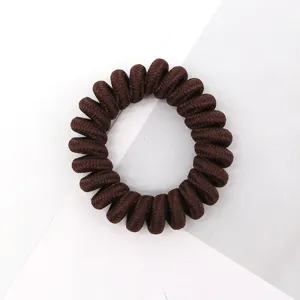 Brown telephone cord hair tie detail, showing the textured fabric wrap and high elasticity.