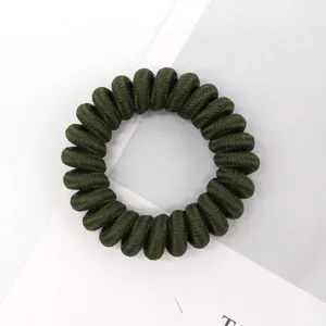 Dark green telephone wire hair tie detail, elastic spiral hair band, simple hair accessory.