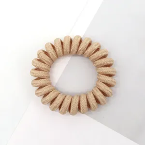Detailed shot of beige woven telephone wire hair tie, showing delicate braided texture and elasticity.