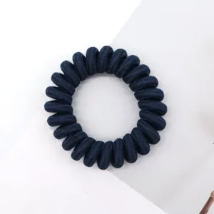 Close-up detail shot of a dark blue telephone wire hair tie showing texture and high elasticity.