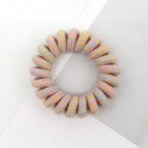 Detailed shot of a colorful woven telephone cord hair tie, stylish and elastic hair accessory.