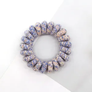 Detail shot of retro woven telephone wire hair tie with blue and beige pattern, high elasticity.