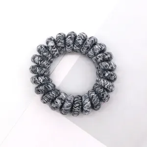 Detailed close-up view of the braided black and white phone cord hair tie, textured surface.