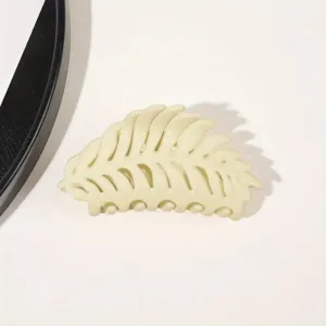 Detailansicht einer beigen Blatt Haarklammer, mattiertes ausgehöhltes Design für Frisuren.