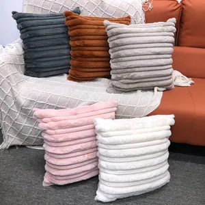 Detailed view of striped faux fur throw pillow covers shown in a cozy home setting.