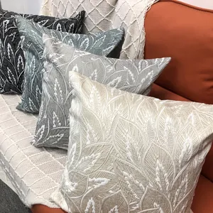 Vista detallada de la funda de cojin con patron de hojas texturizadas, elegante funda de sofa.