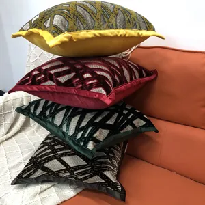 Detailed view of textured cut velvet throw pillows stacked on a cozy orange sofa.