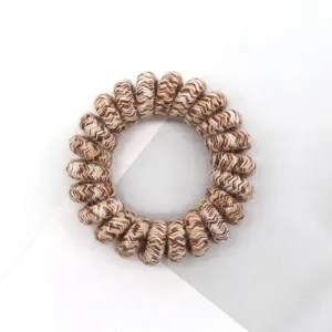 Brown and white woven spiral hair tie, stylish and retro hair accessory for women and girls.