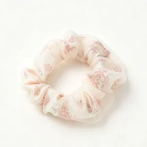 Close-up of a soft sheer mesh hair scrunchie with delicate pink floral print details.