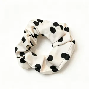 Classic black and white polka dot hair scrunchie, elegant fabric design for daily wear and styling.