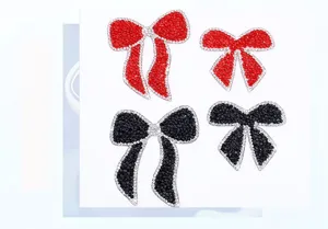 Detail view of sparkling rhinestone bow patches, featuring red and black crystal designs.