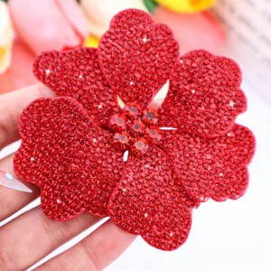Red rhinestone flower patch close-up, sparkly crystal floral applique for shoes.